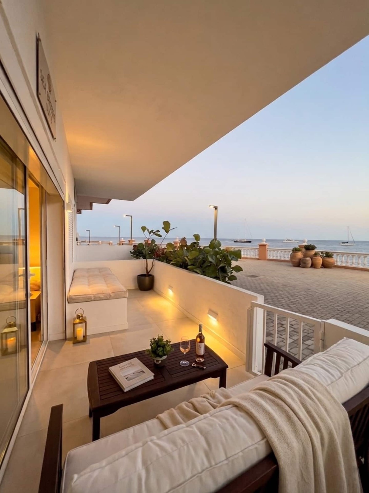 Sea-facing terrace with cushioned seating at dusk
