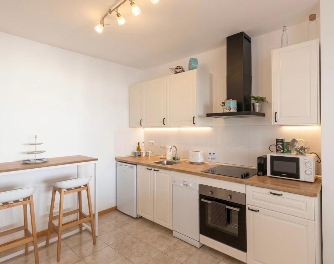 Kitchen with an oven, microwave and a breakfast bar