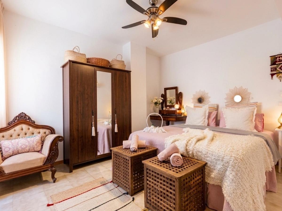 Double bedroom with a carved wardrobe and a ceiling fan